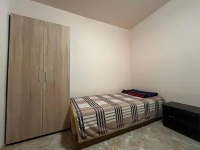 a bedroom with a bed and a wooden cabinet at VIGO Nessebar in Nesebar