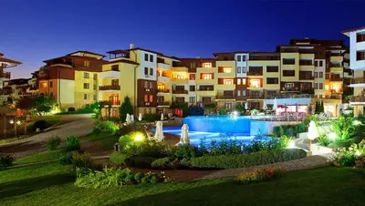 a large apartment building with a swimming pool at night at Аpartment in the Garden of Eden in Sveti Vlas