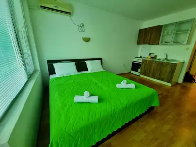 a bedroom with a green bed with two towels on it at NeV Getaway for 2 in Burgas City