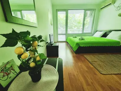 a bedroom with a green bed and a table with a plant at NeV Getaway for 2 in Burgas City