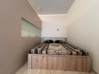 a bedroom with a bed with a wooden bed frame at Villa ROMA apartaments&SPA in Nesebar