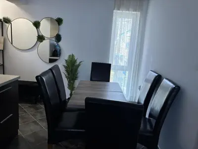 a dining room with a wooden table and black chairs at Divine place Pomorie in Pomorie