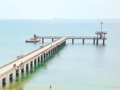 a pier in the water with people walking on it at Lazur Studio in Burgas City