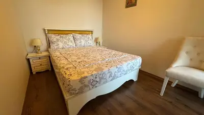a small bedroom with a bed and a chair at Апартамент Панорама, двустаен, малък, първа линия, гледка море, DIAMOND BEACH, Сарафово in Burgas City