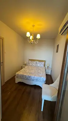a bedroom with a bed and a chandelier at Апартамент Панорама, двустаен, малък, първа линия, гледка море, DIAMOND BEACH, Сарафово in Burgas City