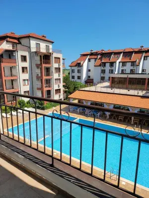 a view of a pool from a balcony with buildings at Famagusta Antoniya in Aheloy