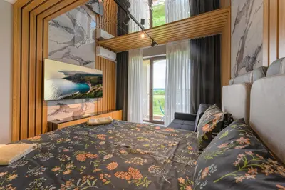 a bedroom with a bed and a large window at Azur Properties ap50 in Shkorpilovtsi