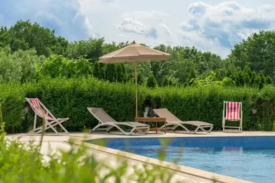 a group of chairs and an umbrella next to a pool at Azur Properties ap50 in Shkorpilovtsi