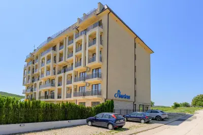 a building with cars parked in front of it at Azur Properties ap51 in Shkorpilovtsi