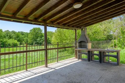an outdoor patio with a bench and a grill at Azur Properties ap51 in Shkorpilovtsi