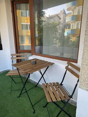 a wooden table and two chairs next to a window at Studio by the sea in Primorsko