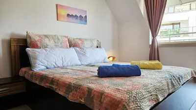 a bedroom with a bed with two pillows on it at Апартамент Комфорт in Varna City