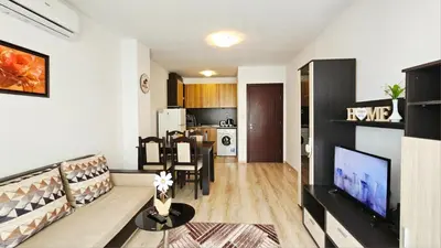 a living room with a couch and a tv at Апартамент Комфорт in Varna City