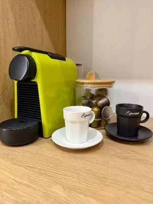 a yellow toaster and two coffee cups on a counter at Апартамент Vista Al Mar in Pomorie