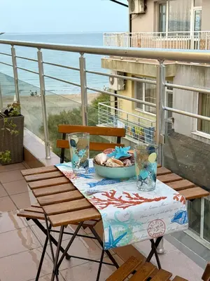 a table with a bowl of food on a balcony at Апартамент Vista Al Mar in Pomorie