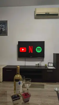 a bottle of wine sitting on a table next to a tv at Kalia D11 Słoneczny Brzeg Sunny Beach in Sunny Beach