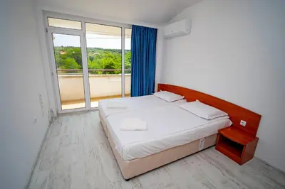 a bedroom with a bed and a large window at Next to Harmanite Beach - 1 BD Flat with Own Parking spot by Flat Mаnager in Sozopol