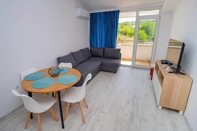 a living room with a table and a couch at Next to Harmanite Beach - 1 BD Flat with Own Parking spot by Flat Mаnager in Sozopol