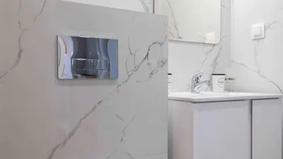 a white bathroom with a sink and a mirror at Sea Holiday 21 in Burgas City
