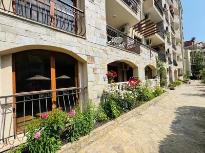 a facade of a building with flowers and an umbrella at KALIA C2 Two Bedroom Apartment Sunny Beach in Sunny Beach