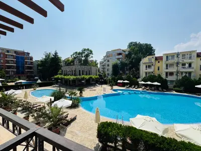 a large swimming pool with white umbrellas and buildings at KALIA C4 One Bedroom Apartment Sunny Beach in Sunny Beach