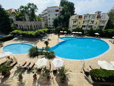 a large swimming pool with chairs and umbrellas at KALIA C9 One Bedroom Apartment in Sunny Beach