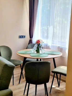 a table with chairs and a table with a flower on it at Fresh & Cozy Flat Near Varna Cathedral in Varna City