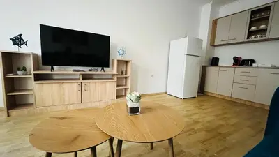 a living room with a table and a tv and a kitchen at ASTORIA II Apartment 13 One Bedroom Parter in Elenite