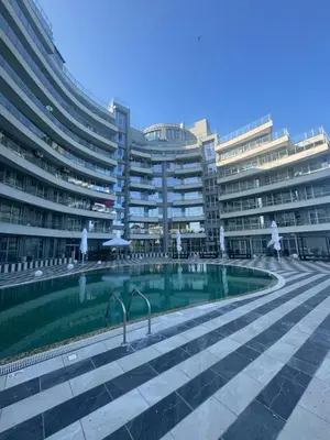 a swimming pool in front of a large building at Allure by the Sea in Primorsko