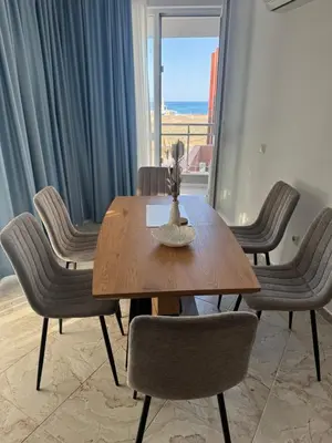 a dining room table and chairs with a view of the ocean at Allure by the Sea in Primorsko