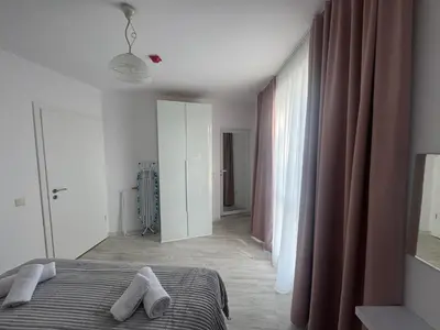a bedroom with a bed with two white towels on it at Allure by the Sea in Primorsko