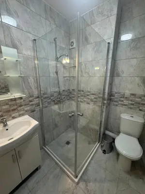 a bathroom with a shower and a toilet and a sink at Allure by the Sea in Primorsko