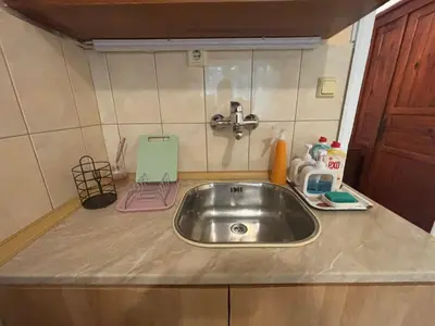 a kitchen counter with a sink in a kitchen at Апартамент за гости Весела in Burgas City
