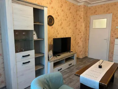 a living room with a television and a table at Апартамент за гости Весела in Burgas City