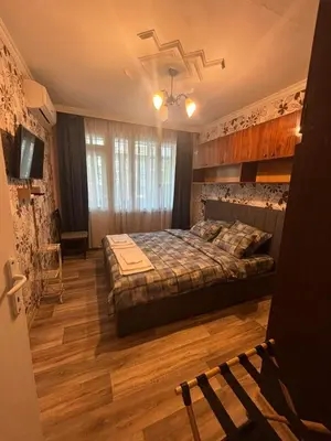 a bedroom with a bed in a room with wooden floors at Апартамент за гости Весела in Burgas City