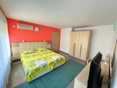 a bedroom with a bed and a red wall at Apartment Lotus in Sveti Vlas