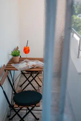 a table with two chairs and a drink on it at Apartment Lotus in Sveti Vlas