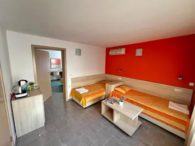 a room with two beds and a red wall at Apartment Lotus in Sveti Vlas