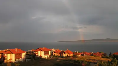 a group of houses on a hill with a rainbow at High in the Sky Apartments in Sozopol