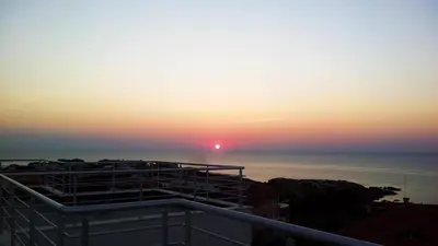 a sunset from the balcony of a building at High in the Sky Apartments in Sozopol