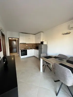a kitchen and dining room with a table and chairs at Двуспален апартамент Оазис Бийч Клуб in Lozenets