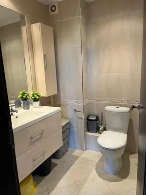 a bathroom with a toilet and a sink at Двуспален апартамент Оазис Бийч Клуб in Lozenets