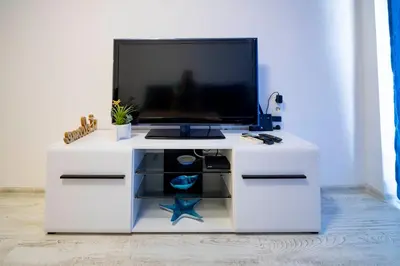 a white desk with a tv on top of it at Harmani Haven 1BD Apartment with Own Parking spot by Flat Manаger in Sozopol