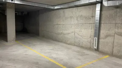 an empty parking garage with a concrete wall at Тони апартмент in Burgas City