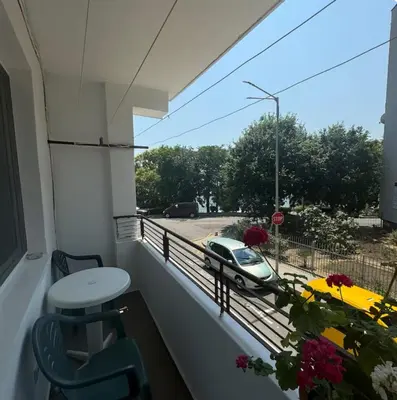 a balcony with a table and a car on a street at Anastasiya's Flat in Pomorie