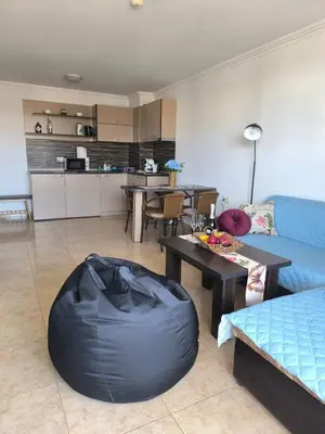 a living room with a blue couch and a table at Апартамент Кара миа in Sveti Vlas