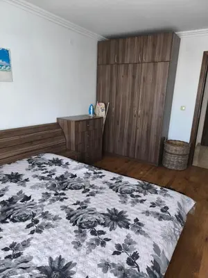 a bedroom with a bed with a black and white blanket at Апартамент Кара миа in Sveti Vlas