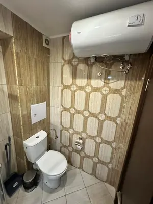 a small bathroom with a toilet and a water tank at PSB Apartment in Paradiso in Nesebar