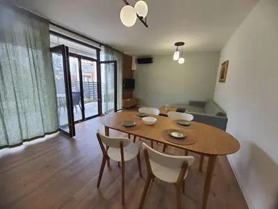 a living room with a wooden table and chairs at Вила Фамилия - Villa Family in Lozenets