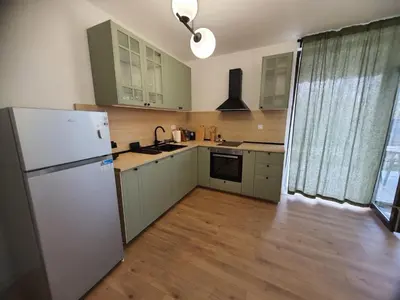 a kitchen with green cabinets and a white refrigerator at Вила Фамилия - Villa Family in Lozenets